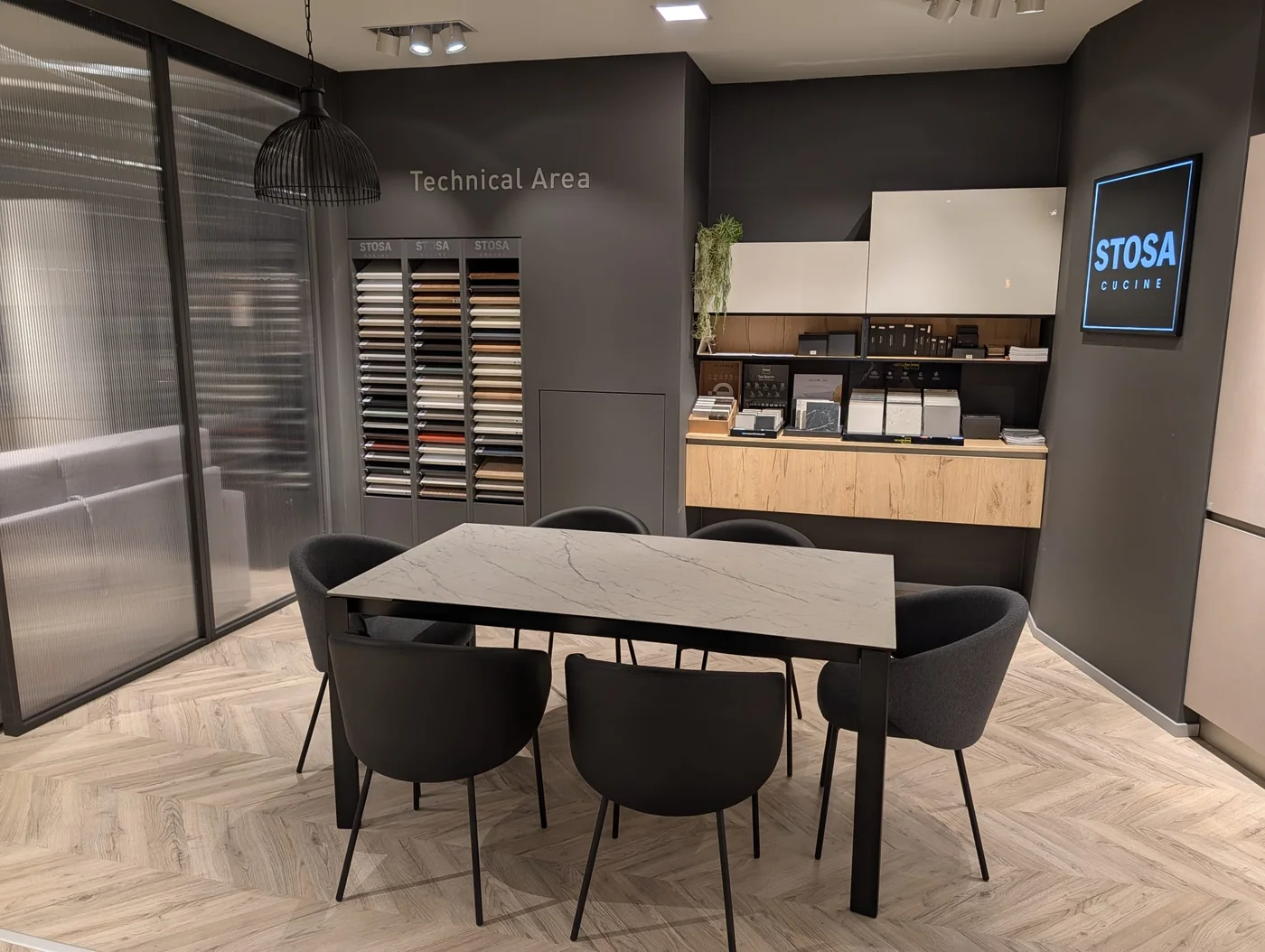 Area di consulenza con tavolo e campioni di materiali e finiture STOSA a Veduggio