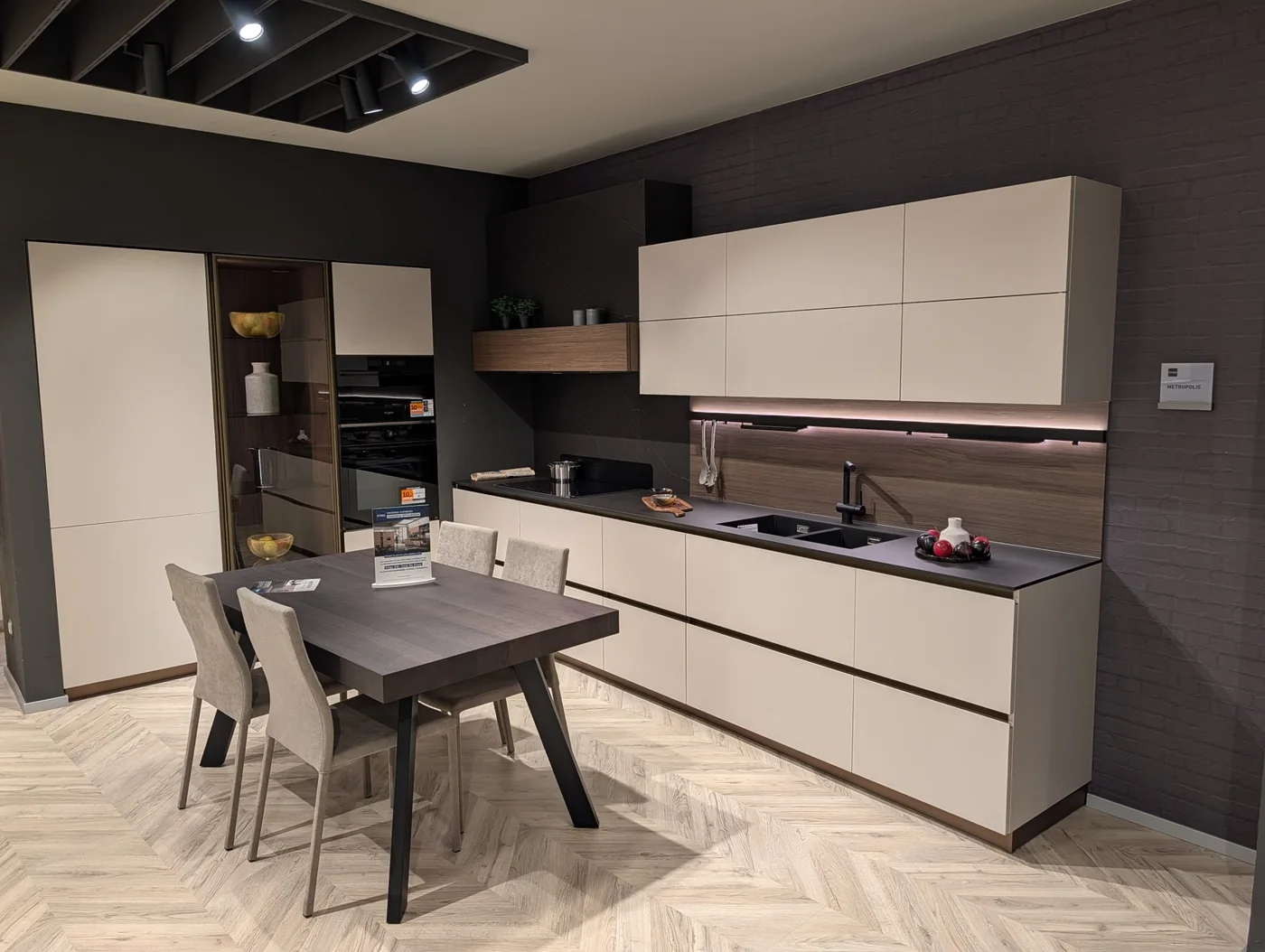 Cucina con ante chiare, top scuro e tavolo coordinato in esposizione a Veduggio