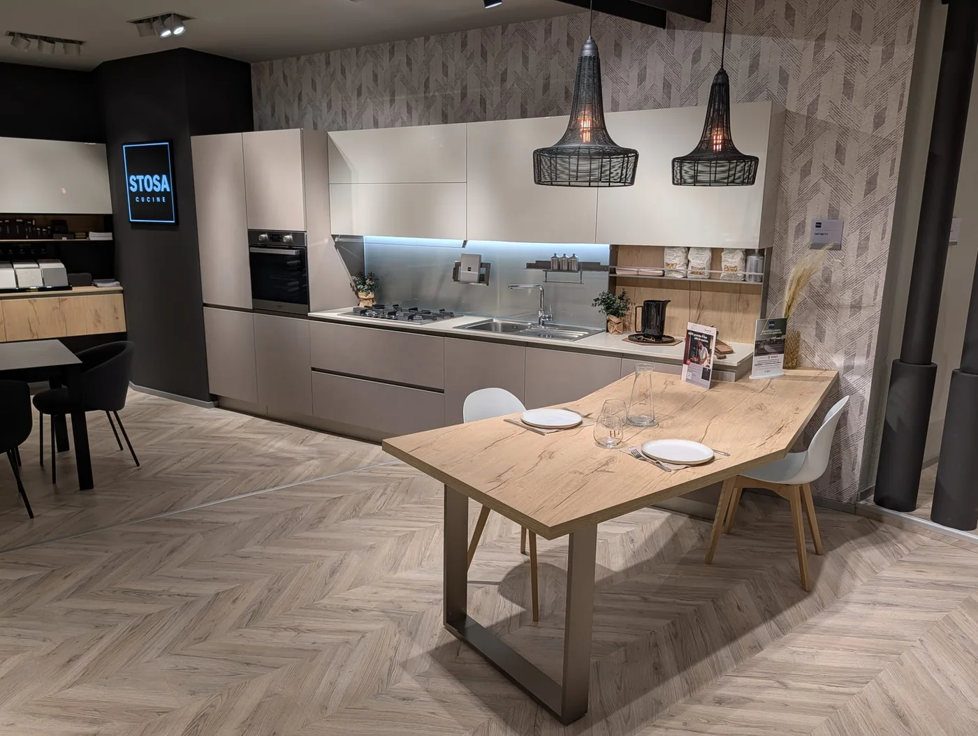 Cucina lineare con pensili bianchi, basi tortora e tavolo in legno a Veduggio