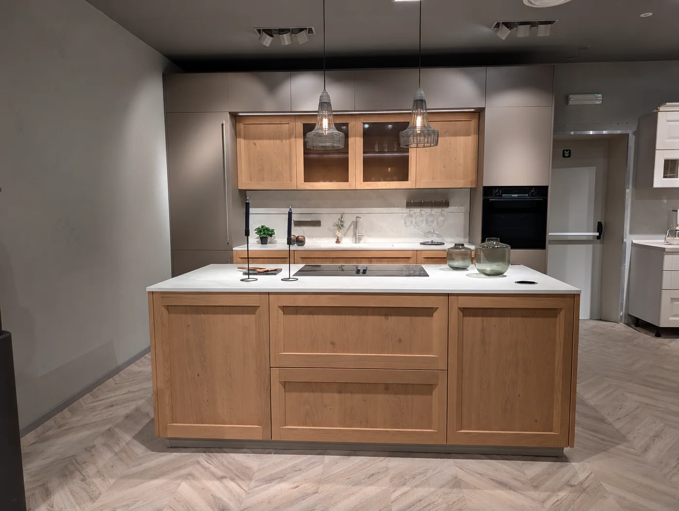 Cucina Palio con isola in legno e piano chiaro nello showroom di Veduggio