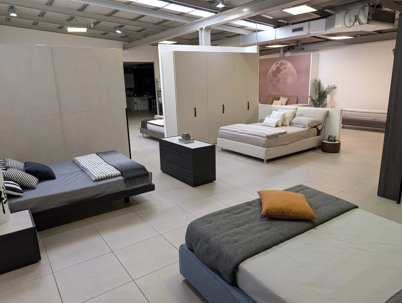 Letti e armadi nella zona notte dello showroom di Veduggio